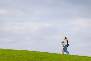 Woman with her dachshund dog walking in the park