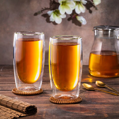 Black tea in a glass teapot and cups. On a dark background. Tea concept.