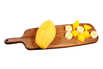 Mango and banana pieces on the cutting board, isolated on a white background. Sliced banana and mango on dark wooden board