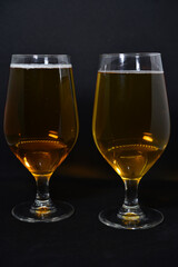 A glass of light beer on a black background. Fresh beer from a glass.