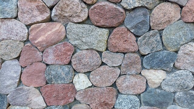 Mauer aus halbierten vormals runden Granitsteinen