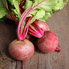 Fresh beetroot with leaves on a wooden background. Healthy food. Top view. Free space for your text
