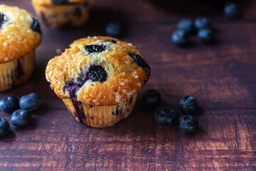 freshly baked homemade blueberry muffins on wooden table background.