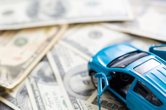 Toy car, money, documents. The concept of buying and insuring cars. Car, money