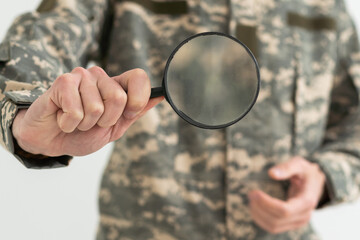 military man holding a magnifying glass