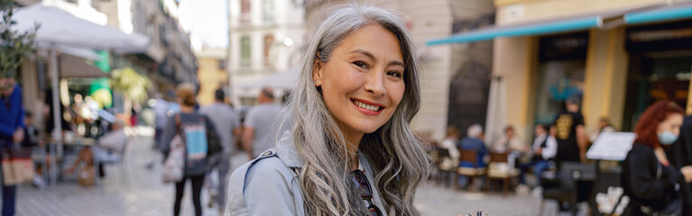 Attractive mature woman with camera on city street