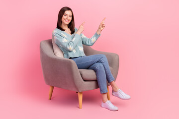 Obraz na płótnie Canvas Full body photo of young girl sitting comfortable chair direct finger waiting empty space stomatology isolated on pink color background