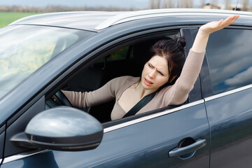 An angry girl grips the steering wheel tightly, frustration evident in her eyes. Stuck in slow...