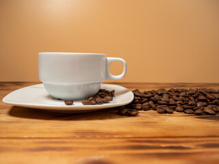 Obraz premium Cup of coffee and roasted coffee beans on a wooden background.