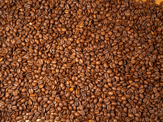 Background from roasted coffee beans. Scattered coffee beans.