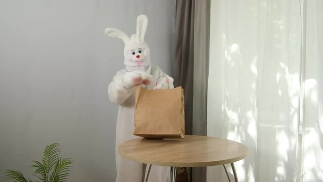 The white rabbit takes out the gift boxes from the bag.
