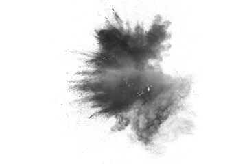 Black powder explosion. The particles of charcoal splatter on white background. Closeup of black...