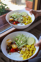 woman hands holding two vegetables bowls