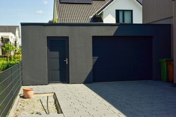 Moderne Beton-Garage mit Automatik-Tor in der Hauszufahrt