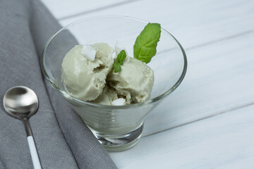 Natural matcha ice cream with coconut in a glass bowl