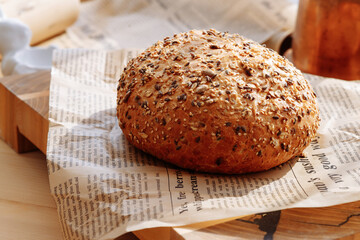Freshly baked sourdough bread with a golden crust on a wooden cutting board. Round bread close-up. Bakery context with delicious bread. Confectionery.