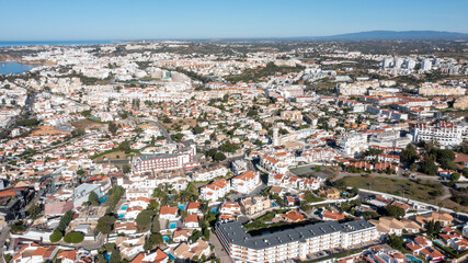 Obraz premium Aerial photo of the beautiful town in Albufeira in Portugal showing the pretty town on a hot summers day with blue skies on a hot summers day in the summer time.