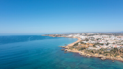Fototapeta na wymiar Aerial photo of the beautiful town in Albufeira in Portugal showing the Praia de Albufeira golden sandy beach, with hotels and apartments in the town, taken on a summers day in the summer time.