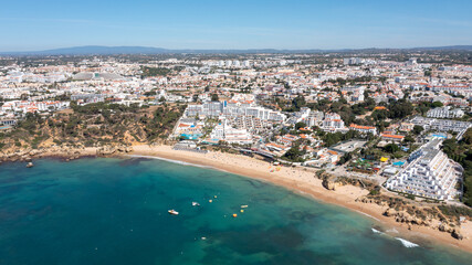 Aerial photo of the beautiful town in Albufeira in Portugal showing the Praia da Oura golden sandy beach, with hotels and apartment in the town, taken on a summers day in the summer time.