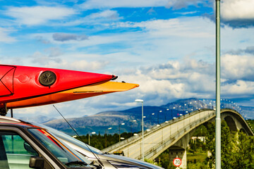 Car with canoes on top roof in mountains
