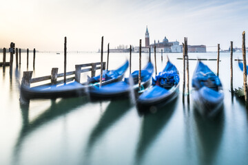 Blue gondolas in Venice in slow pose.  Italy