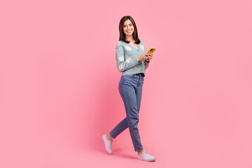Fototapeta na wymiar Full length photo of cute pretty woman dressed teal outfit communicating modern gadget arm isolated pink color background