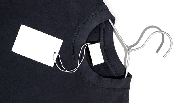 Black t-shirt with blank clothing price tag or label mockup on a clothes rack. Ecology concept. Clothing sale concept