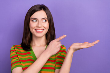 Photo of friendly woman straight hairstyle wear colorful t-shirt indicating look at sale on palm empty space isolated on purple background