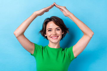 Photo of attractive smiling happy bob brown hair lady wear green t-shirt show hands roof protection feel save isolated on aquamarine color background © deagreez