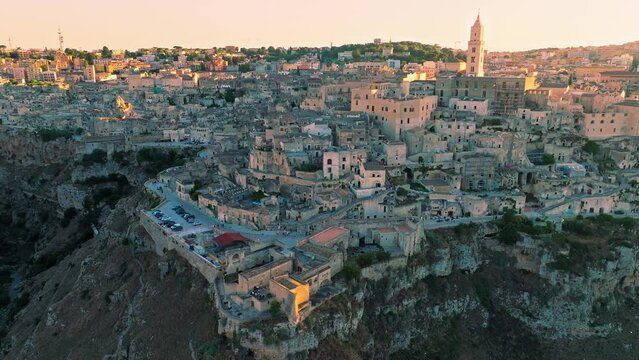 Stunning aerial sunset view over Sassi di Matera Old Town with cave dwellings. Golden sunset over famous historical ancient Cattedrale di Maria Santissima della Bruna e Sant'Eustachio in Italy, Europe