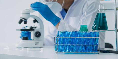 hand of scientist with test tube and flask in medical chemistry lab blue banner background