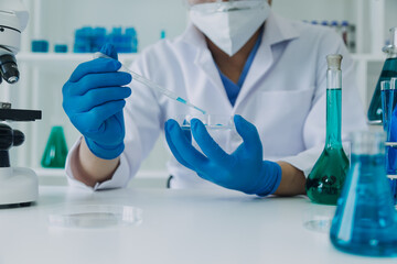 Fototapeta premium hand of scientist with test tube and flask in medical chemistry lab blue banner background
