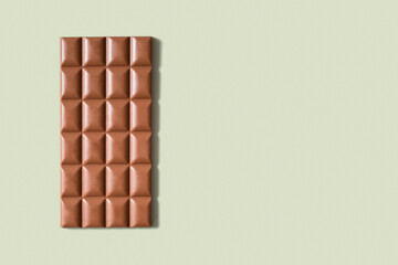 Chocolate bar flat lay, top view on pastel green background with copy space