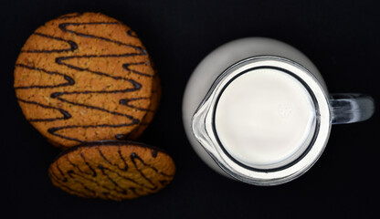 A jug of milk and oatmeal cookies. Delicious breakfast. Oatmeal cookies with milk.