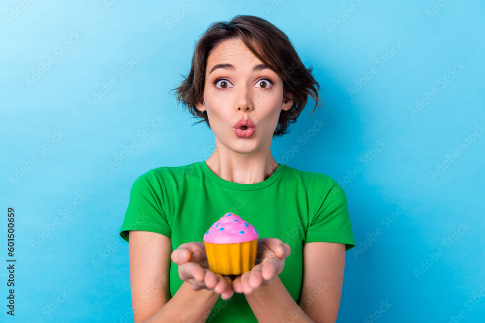 Sticker photo of excited impressed woman wear green t-shirt holding arms little muffin isolated blue color b