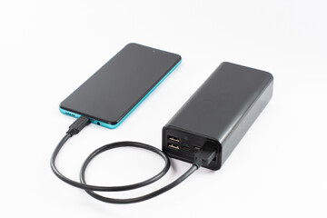 power bank with charging cable and phone, copy space and white background.