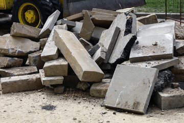 Construction waste. A pile of cement pressed materials, concrete debris, of grey slabs, curbs and rubble. Repair pavement laying. Industrial concept. Municipal service.