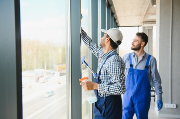 bearded man washing office windows near blurred multicultural women, banner