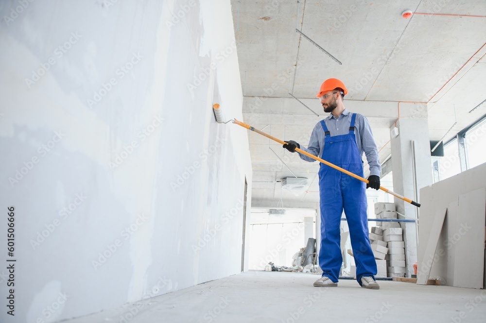 Wall mural painter man painting the wall, with paint roller