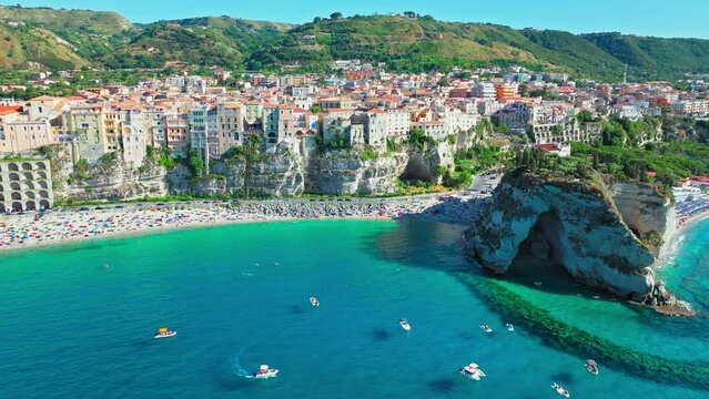 Top view of people relaxing at Shore of Tropea and Spiaggia della Rotonda beach. View from above of tourists having good time on a vacation in the byzantine historical town in ProRez.