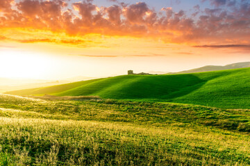 Obraz premium amazing sunset among green spring hills in highland farm with castle , mountains and picturesque colorful sunset on background of landscape