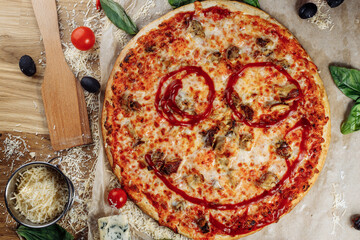 Pizza with chicken cheese and pepperoni, a piece of which is cut and laid out like a pakman, is on a wooden board and a brown background. Cheese spreads flowing streaks
