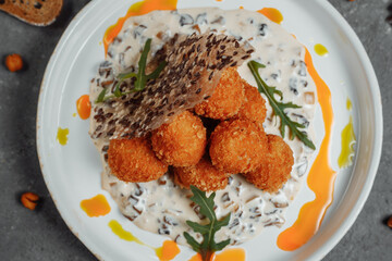 Potato croquettes - mashed potatoes balls breaded and deep fried, served with different sauce.