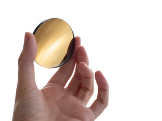 brown colored lens for eyewear, hand holds a round dark glass lens for sunglasses on white...