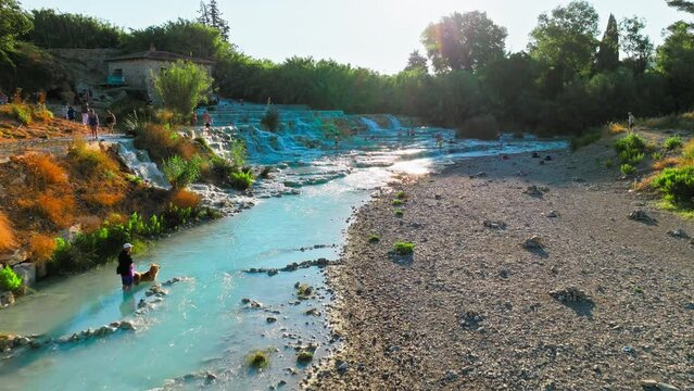 Aerial view of hot springs and thermal waters in Saturnia, Tuscany. View from above of people taking baths and enjoying the spa town in Tuscany in 4K PoRes.