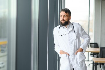 Portrait of pleasant young Arabian doctor in white coat.