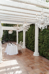 wedding arch for an outdoor wedding ceremony on a green lawn, decorated with white flowers