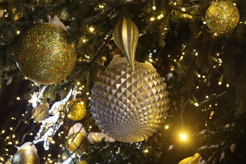 Krakow New Year's tree decorated with garlands of white and gold. Glass balls, sweets and toys hanging from the branches bring joy and warmth to the hearts