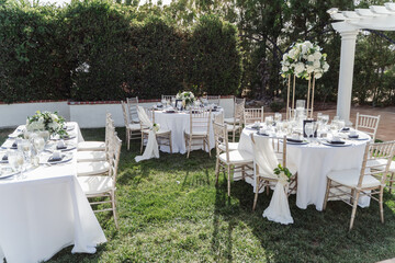 wedding arch for an outdoor wedding ceremony on a green lawn, decorated with white flowers
