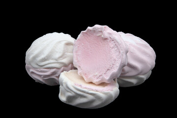 White and pink marshmallows on a black background.